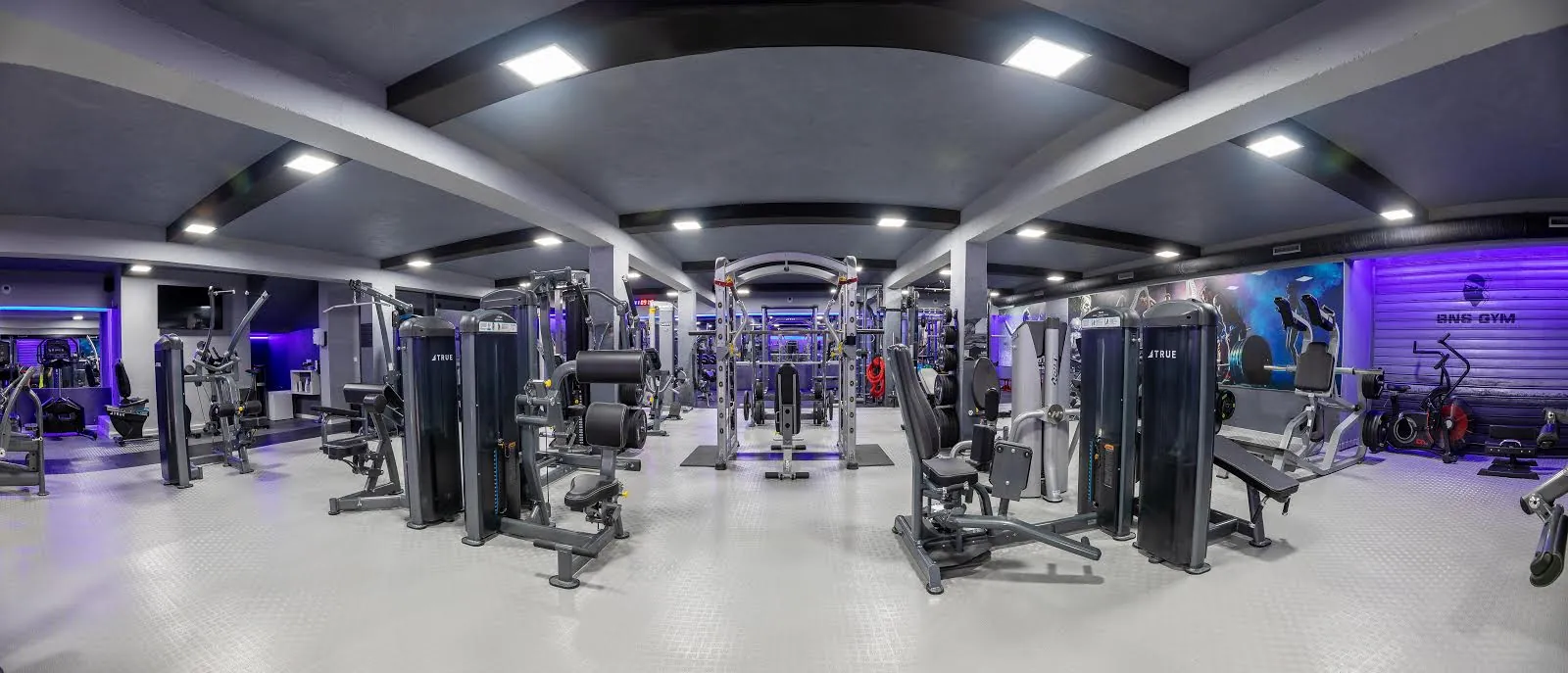 La salle BNS GYM à Bastia : machines True Fitness, cage à squat et éclairage LED